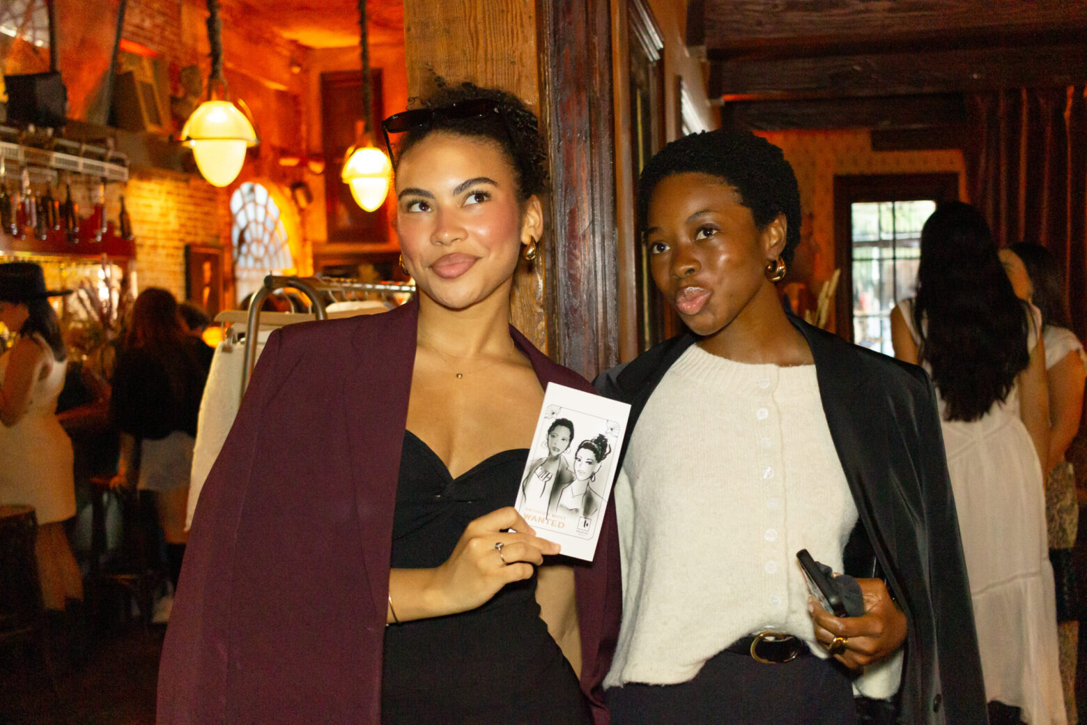 Guests at Anthropologie's Anthro Saloon event in NYC holds up their custom "Wanted Poster" sketch created by Drawing Booth, showcasing their portrait in a Western-themed design.